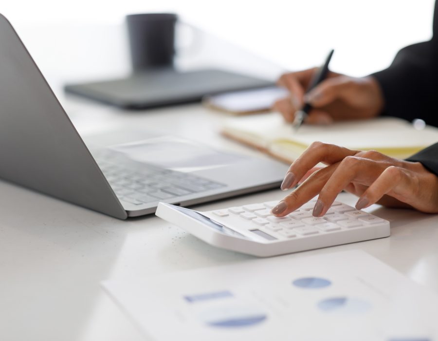 Close up of businesswoman Accounting using calculating income-expenditure and analyzing real estate